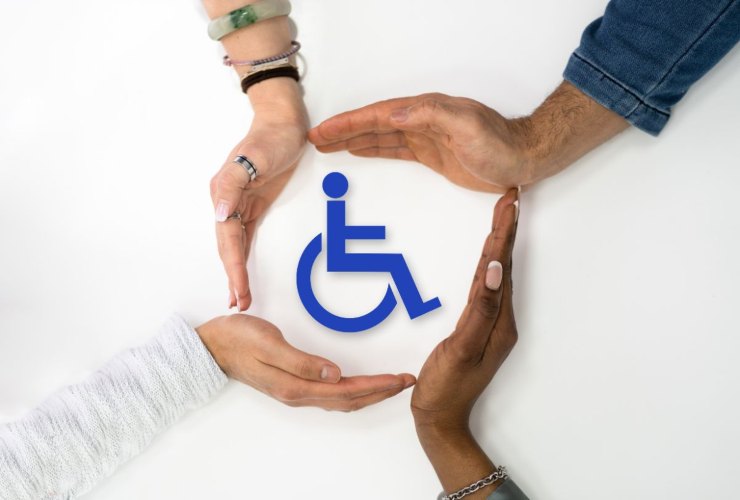Mani che accarezzano e proteggono il simbolo della disabilità