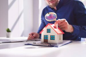 Persona che guarda una casa in miniatura con la lente