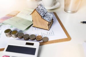 monete, calcolatrice e miniatura casa