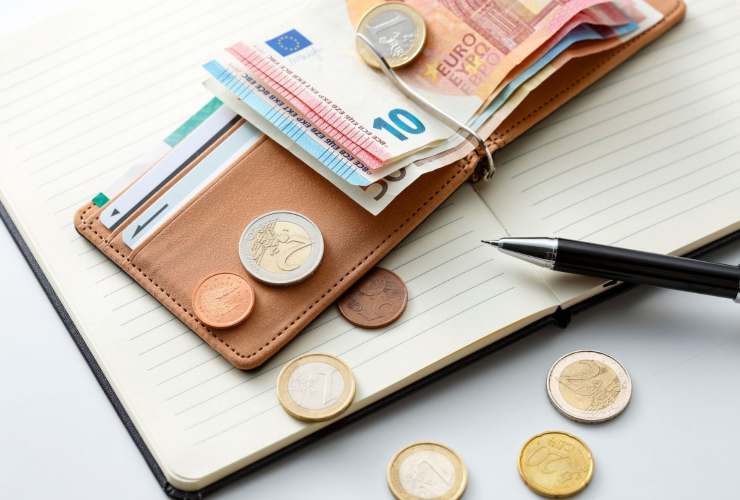 portafoglio con banconote e monete, block notes