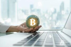 cripotvaluta in una mano e tastiera pc