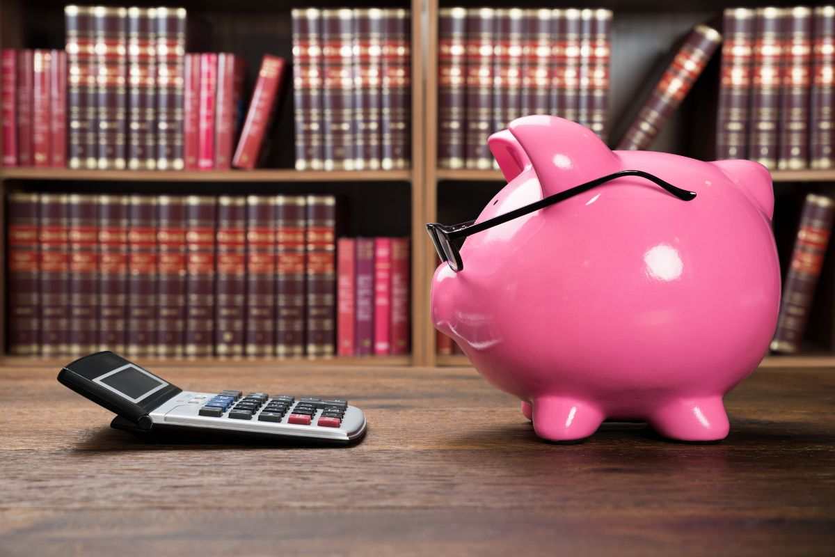 salvadanaio, calcolatrice e libri