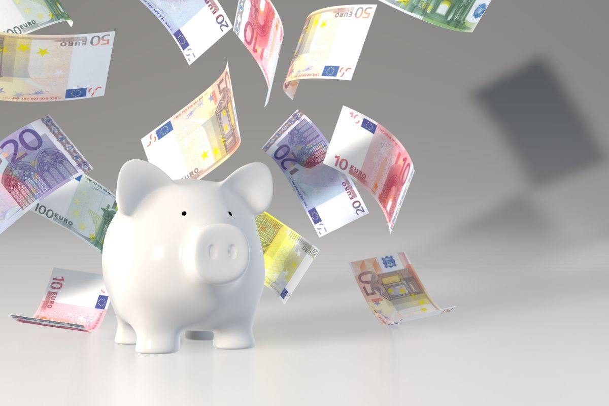 Salvadanaio e banconote che volano