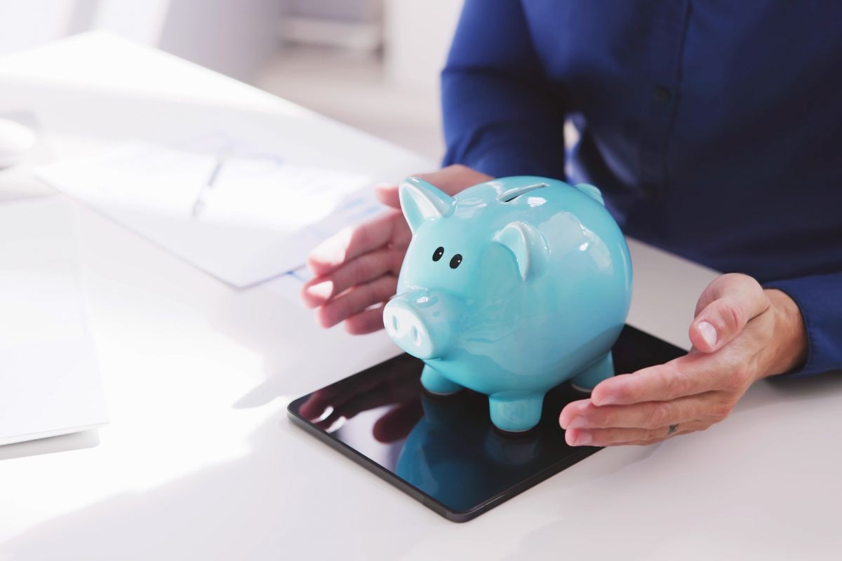 persona che mantiene un salvadanaio fra le mani