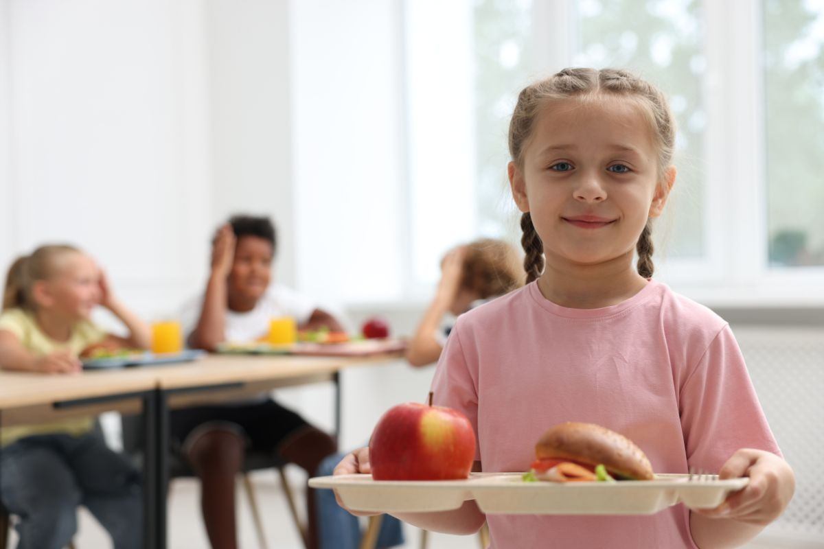 bambina che mangia alla mensa scolastica